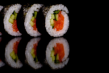 Fresh delicious beautiful sushi rolls on a dark background