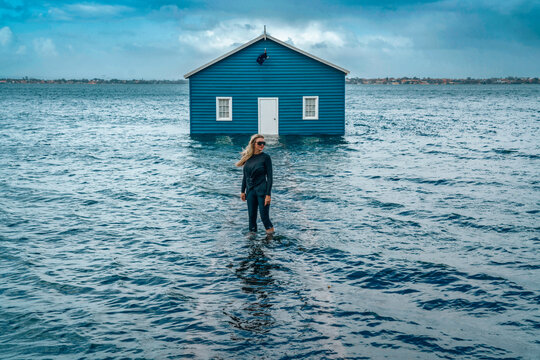 Beautiful Woman Standing In Water By House Against Sky