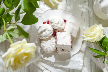 pastille with cranberries and marshmallows(zephyr) top view, next to white roses