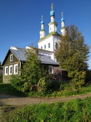 An old wooden village house and white church