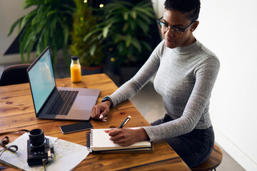 Serious ethnic female student working at table