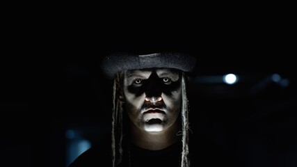 Frightening man face in carnival skull Halloween makeup of skeleton looking creepy at camera on...