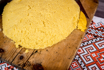 Hot steaming polenta on a old wooden board on the table