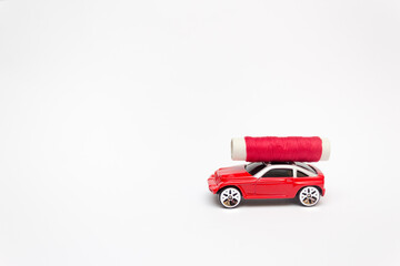 Toy car carries a skein of red thread