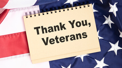 Fototapeta na wymiar Closeup of American flag with text of Thank You, Veteran on the chalkboard