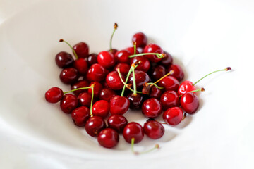 Obraz na płótnie Canvas red cherries in a white bowl