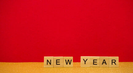 Words  new year are written on wodden blocks on red and gold background. Card. Banner. 2021