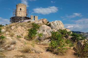 Fototapeta na wymiar This is the Barnabo Grillo tower and ruined wall of Chembalo fortress during the reconstruction. Crimean medieval architecture landmark. Ruined Genoese fortress in Balaklava near Sevastopol, Crimea.