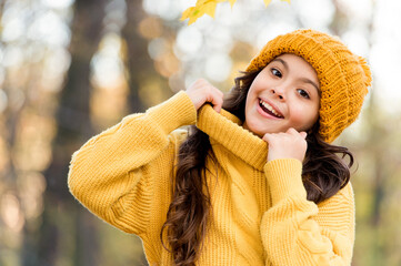 Fresh air and good mood. fall fashion for kids. autumn style of child. knitwear warm you in any weather. girl in knitted sweater and hat. kid enjoy nature in autumn park. fall is a time for fun