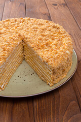 Cut caramel cake on plate on wooden table