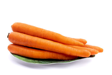 a natural looking bunch of carrots with slight imperfections on a green plate isolated on white