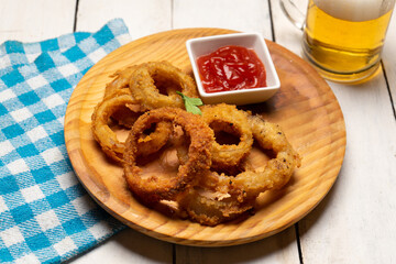 Onion rings with ketchup on white background