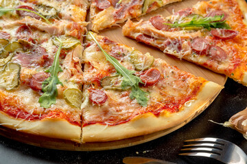 Hunting pizza with cheese, sausage, bacon, chicken, pickles and parmesan.