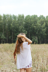 Obraz premium Hippie girl holds a dream catcher at the meadow.