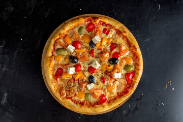 Greek pizza with olives, bell peppers, feta cheese and tomatoes.