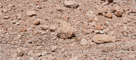 desert bed of a melted glacier made of reddish stones, reminiscent of a Martian landscape