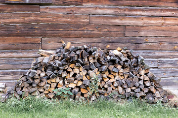 Firewood stacked near wooden brown wall