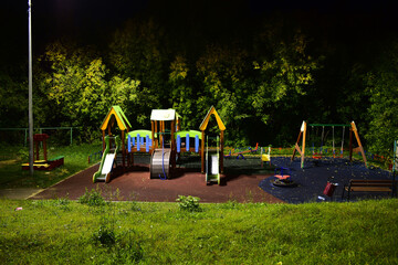 playground in the rays of the lanterns in the late evening