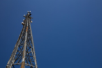 Fototapeta na wymiar Mast of the cellular network over the blue sky