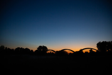 Fototapeta na wymiar silhouette of old bridge in the late evening sunset in Bałobrzegi, Poland.