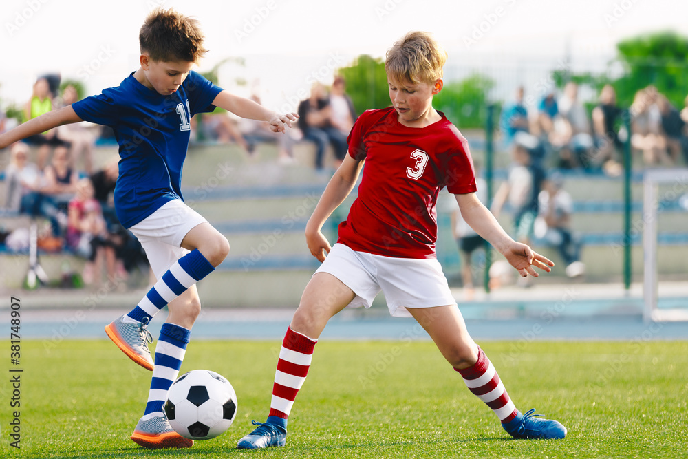 Wall mural happy kids compete in football game. running soccer players. competition between players running and