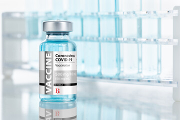 Coronavirus COVID-19 Vaccine Vial Near Test Tubes On Reflective Surface