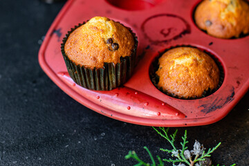 muffins cupcakes chocolate drops
homemade baking cakes on the table christmas lights new year treat tasty serving size top view copy space for text food background rustic