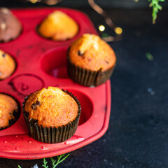 muffins cupcakes chocolate drops
homemade baking cakes on the table christmas lights new year treat tasty serving size top view copy space for text food background rustic
