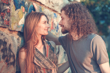 Romantic couple leaning on the wall. Boyfriend tries to kiss his girlfriend.