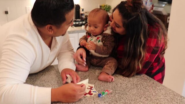 Interracial Parents Painting With Their Mixed Baby During The Holidays