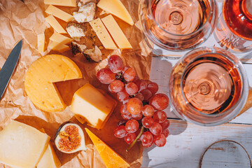 set of different types of cheese. romantic dinner for two. cheese fruit and two glasses of wine