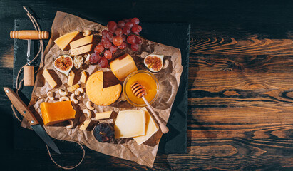 set of different types of cheese. romantic dinner for two. cheese fruit and two glasses of wine