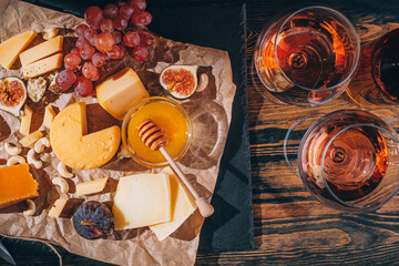 set of different types of cheese. romantic dinner for two. cheese fruit and two glasses of wine