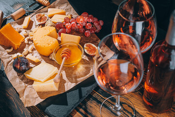 set of different types of cheese. romantic dinner for two. cheese fruit and two glasses of wine