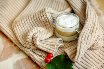 Cup of hot coffee on rustic n table, closeup photo warm sweater with mug, winter morning concept.