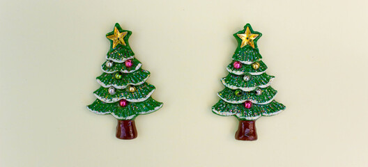 top view Christmas trees on light yellow background. Free copy space. Concept of decoration, greeting cards