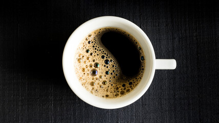 Xícara de café expresso sobre o tampo de madeira preta - Foto ao topo e perfil - obrazy, fototapety, plakaty