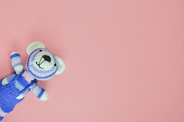 Isolated knitted bear on pink background. Beautiful children's toys. Pink children's background.