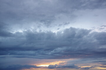 Dark storm clouds with colorful reflections of the setting sun.  Scenic storm clouds lit by the last rays of the sunset.