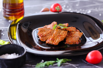 Lamb slow stewed with vegetables in a bowl close-up on dark marble background. meat dish