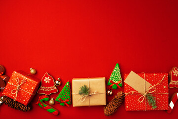 Christmas festive card with wrapped presents and gingerbread biscuits on red
