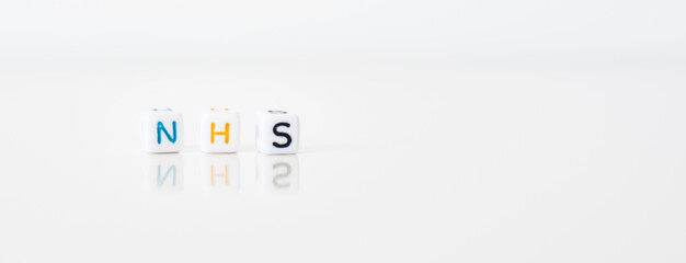 NHS on white background - National Health System word created by cube letters