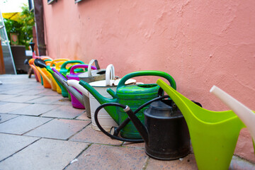 Set of multi-colored plastic watering cans for garden care