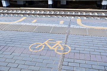 Yellow sign and markings on the asphalt on railway platform indicating entrance to the carriage for...