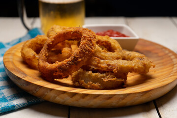 Onion rings with ketchup on white background
