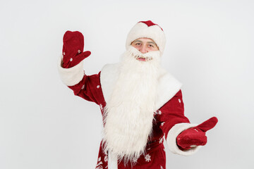 Santa Claus gestures with his hands, spreading them apart from admiration. Isolated background.