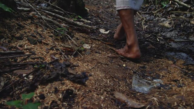 Bare feet walking along jungle path in Bali