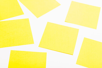 Sheets of yellow paper on a white background. Located randomly.