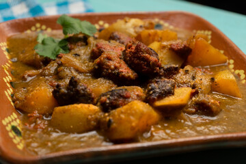 Mexican longaniza with green sauce and potatoes on turquoise background