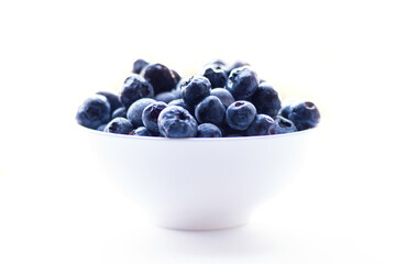 Blueberries in the white bowl on the white background